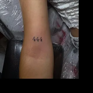 Os números 444 tatuados no antebraço